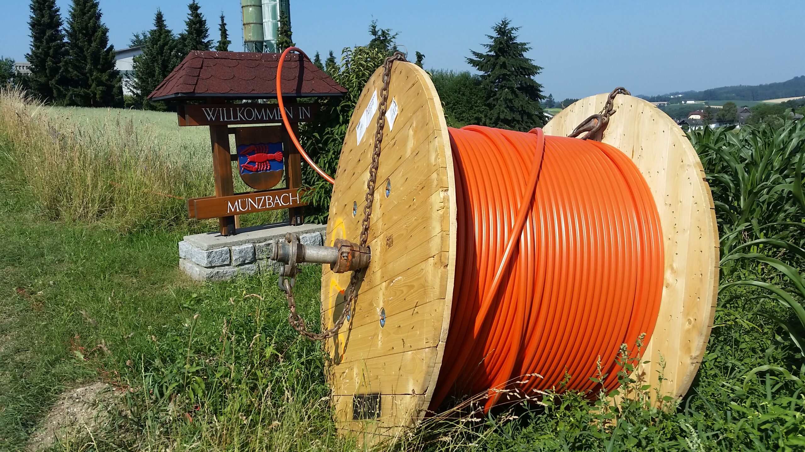 Trommel mit Glasfaserkabel vor der Ortstafel Münzbach